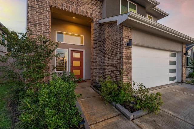 3026 Stock Orchard Ln, Houston, TX 77047 - view of exterior entry featuring brick siding, concrete driveway, stucco siding, and a garage