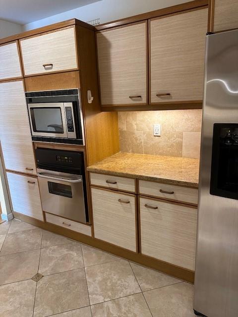 40 N Interstate 35 Unit 3D3, Austin, TX 78701 - kitchen featuring stainless steel appliances, tasteful backsplash, light stone countertops, and light tile patterned floors