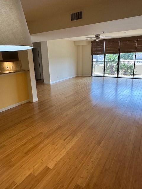 40 N Interstate 35 Unit 3D3, Austin, TX 78701 - unfurnished living room with baseboards and light wood-style floors
