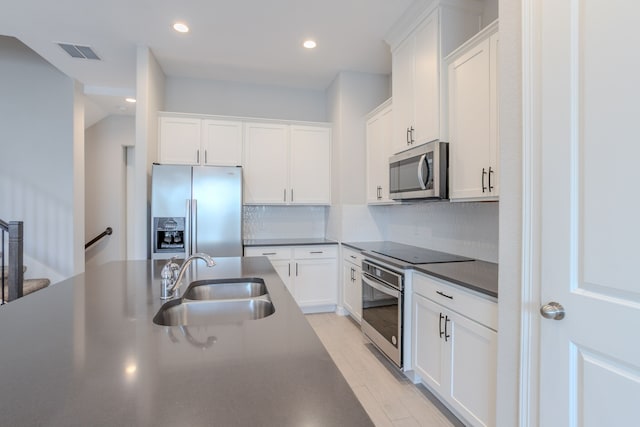 11016 Crescent Light Way, Houston, TX 77043 - kitchen featuring appliances with stainless steel finishes, dark countertops, white cabinetry, backsplash, and recessed lighting