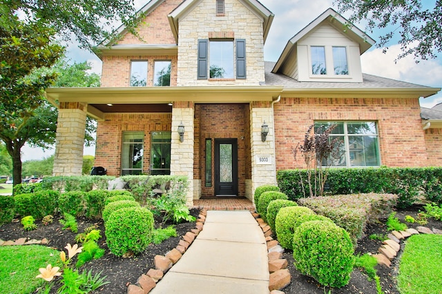 9303 Georgetown Glen Cir, Cypress, TX 77433 - view of front facade with covered porch, stone siding, brick siding, and roof with shingles