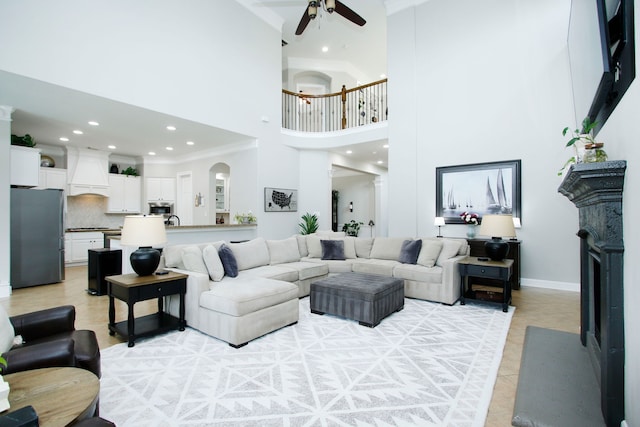 9303 Georgetown Glen Cir, Cypress, TX 77433 - living room featuring a towering ceiling, a ceiling fan, light tile patterned floors, recessed lighting, and arched walkways
