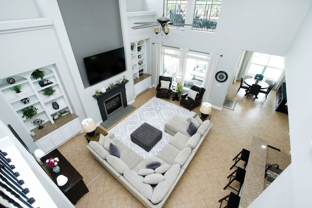 9303 Georgetown Glen Cir, Cypress, TX 77433 - living area with built in features, a high ceiling, light tile patterned flooring, and ceiling fan