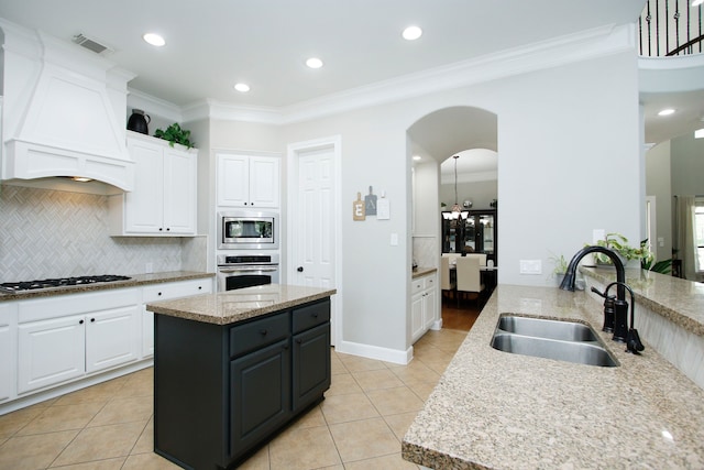9303 Georgetown Glen Cir, Cypress, TX 77433 - kitchen featuring appliances with stainless steel finishes, white cabinetry, light tile patterned floors, backsplash, and crown molding