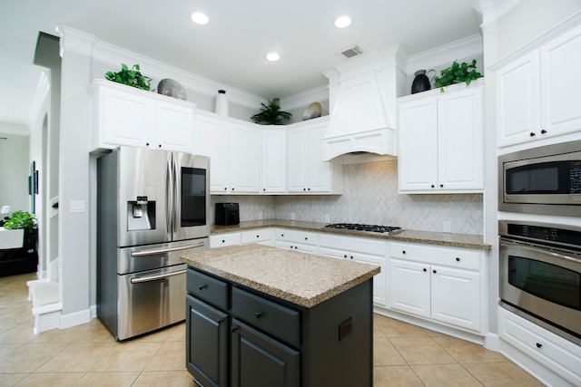 9303 Georgetown Glen Cir, Cypress, TX 77433 - kitchen featuring stainless steel appliances, white cabinets, custom range hood, backsplash, and crown molding
