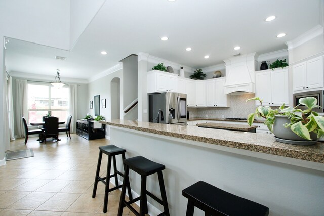 9303 Georgetown Glen Cir, Cypress, TX 77433 - kitchen featuring stainless steel fridge, crown molding, premium range hood, a kitchen breakfast bar, and backsplash