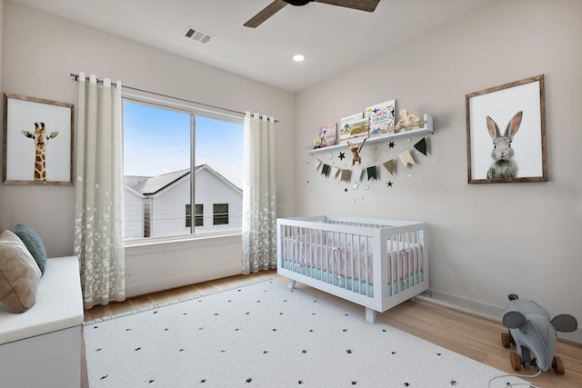 4705 Gibson St, Houston, TX 77007 - bedroom with wood finished floors, a crib, a ceiling fan, and recessed lighting