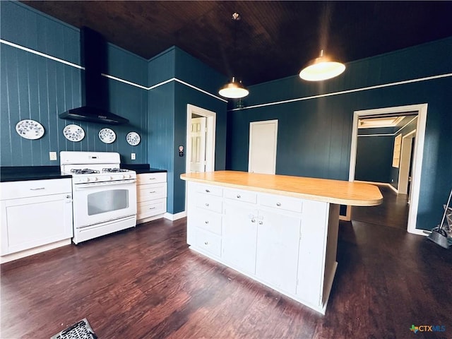 1002 E Gonzales St, Yoakum, TX 77995 - kitchen featuring white range with gas stovetop, dark wood-style floors, white cabinets, and wall chimney exhaust hood