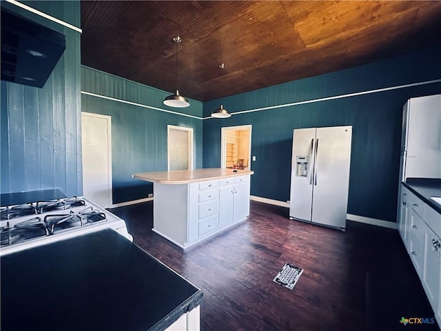 1002 E Gonzales St, Yoakum, TX 77995 - kitchen featuring white refrigerator with ice dispenser, white cabinetry, dark wood-style flooring, a kitchen island, and wooden ceiling