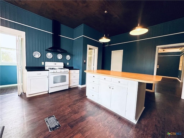1002 E Gonzales St, Yoakum, TX 77995 - kitchen featuring white gas range, wall chimney range hood, dark wood-style flooring, white cabinets, and wooden ceiling