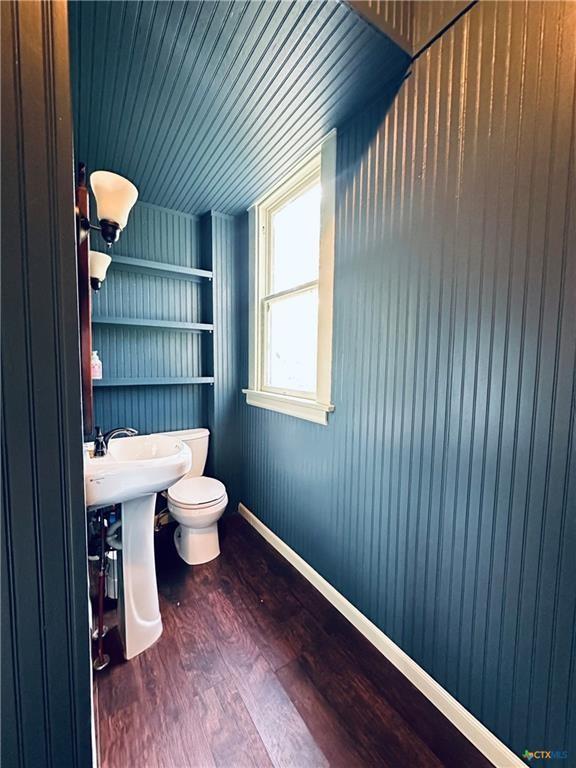 1002 E Gonzales St, Yoakum, TX 77995 - half bathroom with built in shelves and wood finished floors