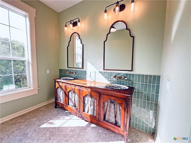 1002 E Gonzales St, Yoakum, TX 77995 - bathroom with tile walls, a wainscoted wall, and vanity