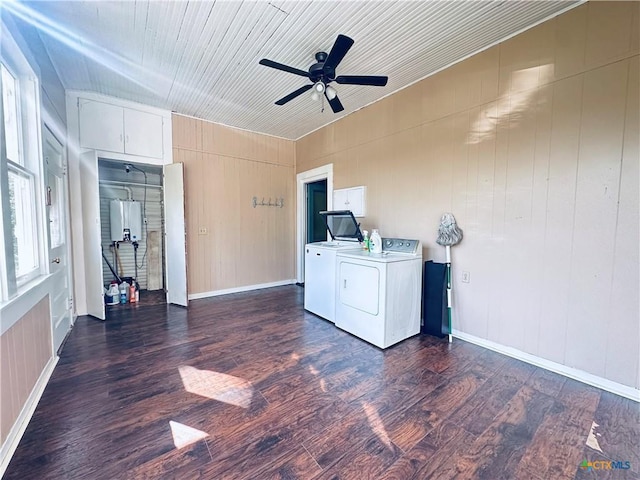 1002 E Gonzales St, Yoakum, TX 77995 - spare room with washer and clothes dryer, dark wood-style floors, a ceiling fan, and water heater