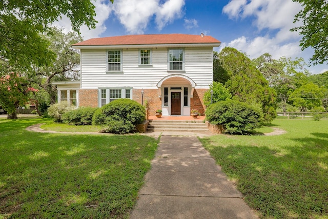 1002 E Gonzales St, Yoakum, TX 77995 - view of front of property with a front yard and brick siding