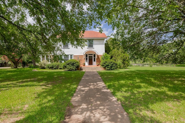 1002 E Gonzales St, Yoakum, TX 77995 - colonial inspired home with brick siding and a front lawn