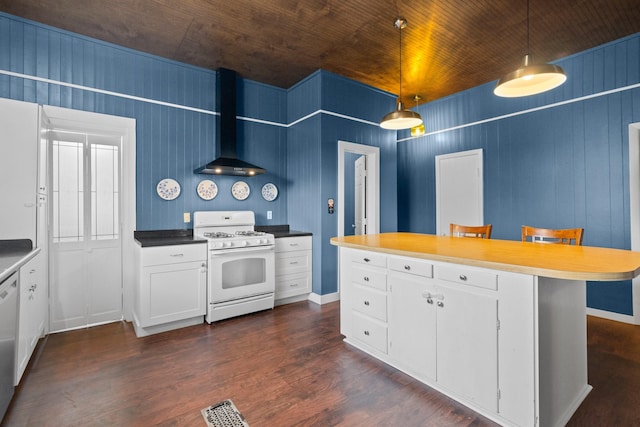 1002 E Gonzales St, Yoakum, TX 77995 - kitchen featuring white appliances, wall chimney range hood, dark wood finished floors, white cabinetry, and decorative light fixtures