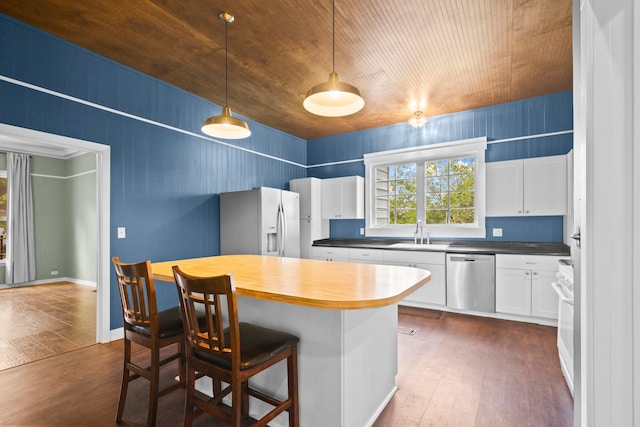 1002 E Gonzales St, Yoakum, TX 77995 - kitchen featuring refrigerator with ice dispenser, dishwasher, dark wood finished floors, white cabinets, and a kitchen breakfast bar