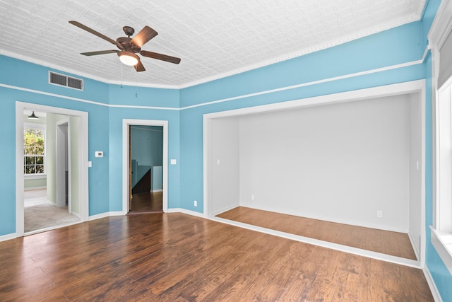 1002 E Gonzales St, Yoakum, TX 77995 - spare room featuring a ceiling fan, wood finished floors, and an ornate ceiling