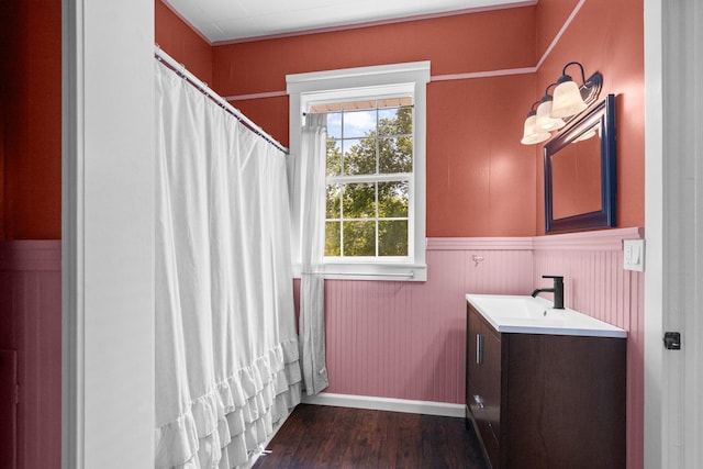 1002 E Gonzales St, Yoakum, TX 77995 - full bathroom featuring vanity, wainscoting, wood finished floors, and curtained shower