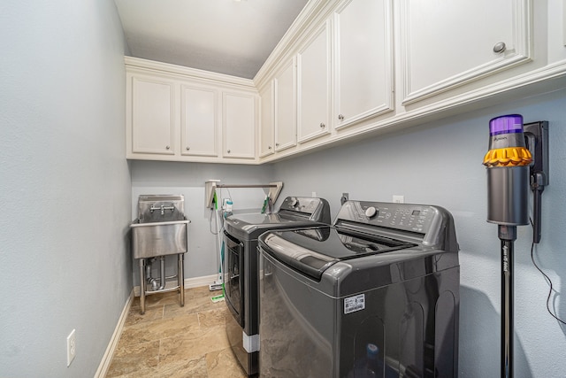 13602 Springmint Dr, Cypress, TX 77429 - laundry area featuring cabinet space, washing machine and dryer, and stone tile flooring