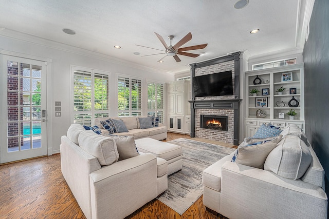 13602 Springmint Dr, Cypress, TX 77429 - living area featuring ceiling fan, ornamental molding, healthy amount of natural light, light wood-type flooring, and a brick fireplace