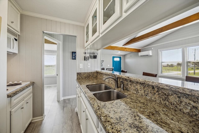 4014 2nd St, Galveston, TX 77554 - kitchen featuring white appliances, a wall mounted air conditioner, light wood-style floors, light stone countertops, and white cabinets
