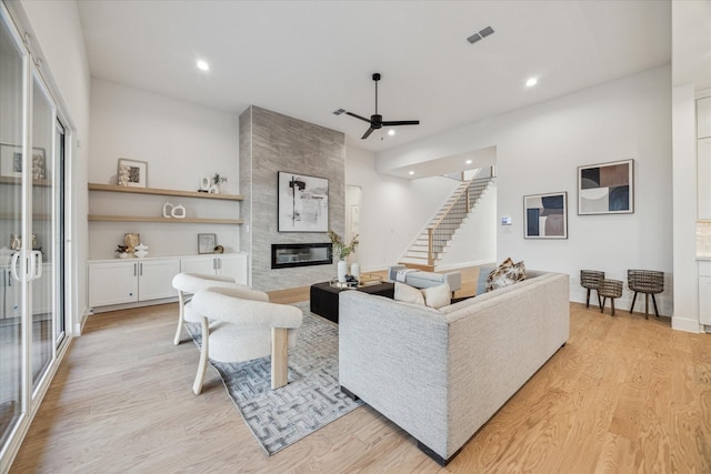 1132 Wakefield Dr, Houston, TX 77018 - living area with light wood-type flooring, a fireplace, ceiling fan, recessed lighting, and stairs