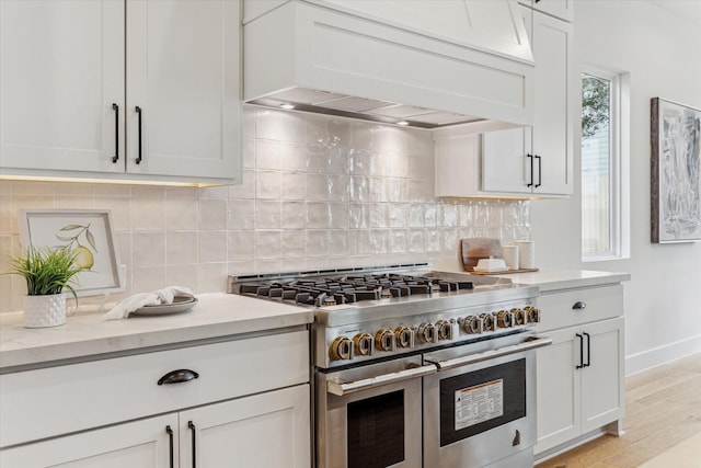 1132 Wakefield Dr, Houston, TX 77018 - kitchen featuring double oven range, premium range hood, backsplash, and light wood-type flooring