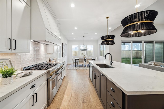 1132 Wakefield Dr, Houston, TX 77018 - kitchen with double oven range, premium range hood, light wood-style flooring, white cabinetry, and recessed lighting
