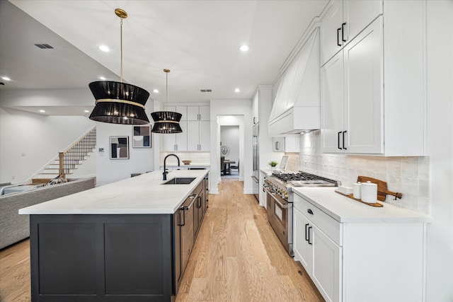 1132 Wakefield Dr, Houston, TX 77018 - kitchen featuring premium appliances, custom exhaust hood, light wood finished floors, white cabinetry, and tasteful backsplash