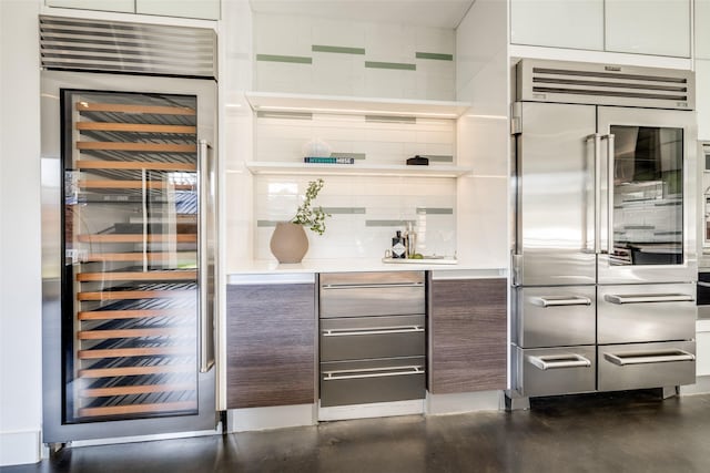 909 Peden St, Houston, TX 77006 - bar featuring built in fridge, wine cooler, backsplash, and finished concrete flooring