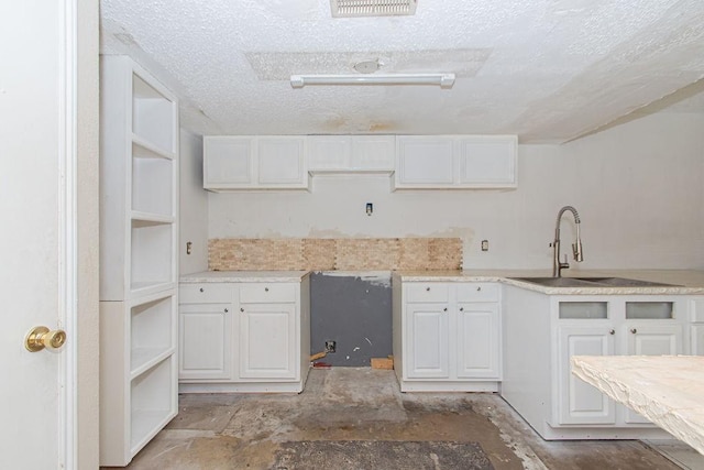 12254 Wild Pine Dr Unit A, Houston, TX 77039 - kitchen featuring a textured ceiling, white cabinets, and light countertops
