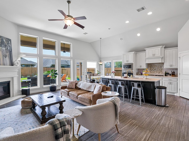 4006 Trento Ct, Katy, TX 77493 - living room with a ceiling fan, recessed lighting, high vaulted ceiling, and a glass covered fireplace