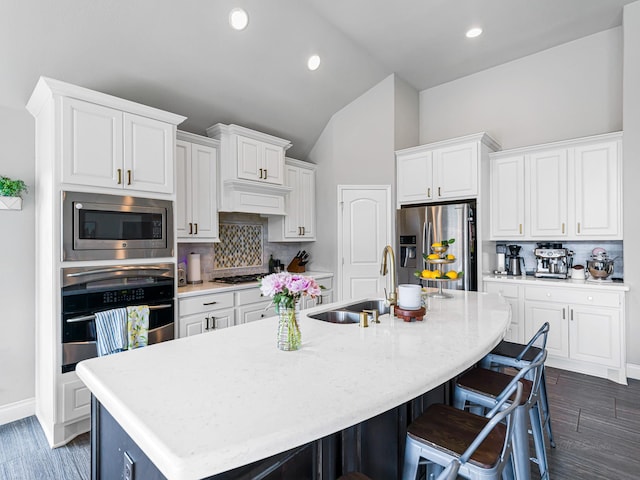 4006 Trento Ct, Katy, TX 77493 - kitchen with stainless steel appliances, decorative backsplash, vaulted ceiling, a kitchen breakfast bar, and an island with sink