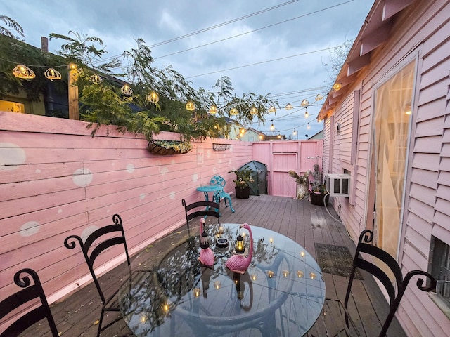 1309 55th St, Galveston, TX 77551 - wooden terrace with outdoor dining space and a fenced backyard
