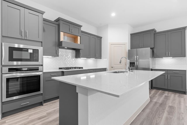 6226 Pelican Ridge Way, League City, TX 77573 - kitchen with stainless steel appliances, gray cabinets, light wood-style floors, a kitchen island with sink, and recessed lighting