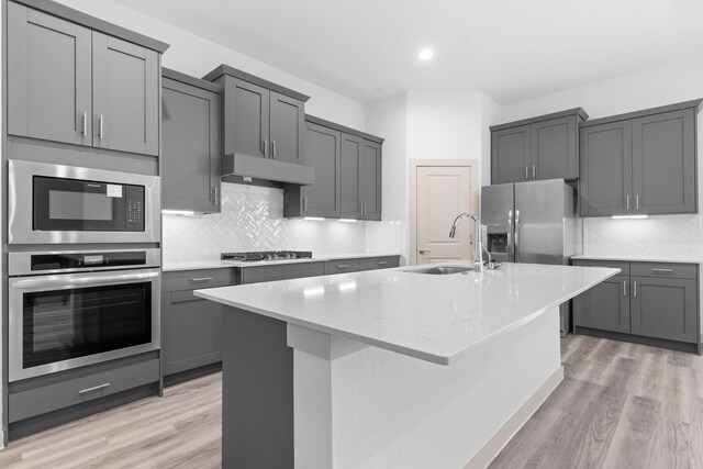 6226 Pelican Ridge Way, League City, TX 77573 - kitchen with stainless steel appliances, gray cabinetry, light wood-type flooring, a center island with sink, and recessed lighting