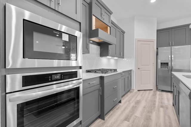 6226 Pelican Ridge Way, League City, TX 77573 - kitchen with stainless steel appliances, gray cabinets, light wood-style flooring, and light countertops