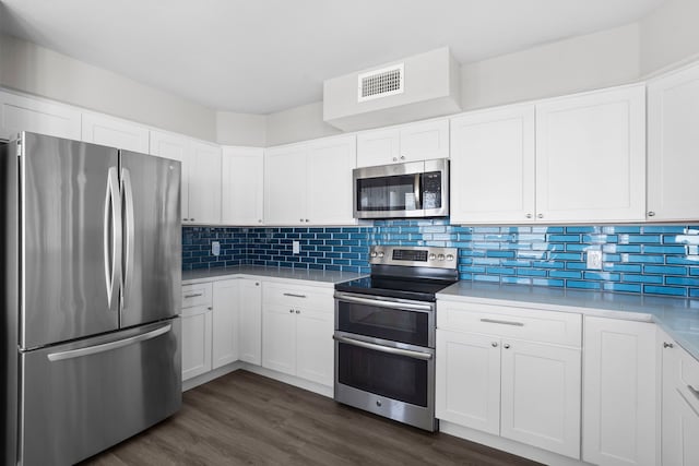 23401 Termini San Luis Pass Rd, Galveston, TX 77554 - kitchen with appliances with stainless steel finishes, dark wood finished floors, tasteful backsplash, and light countertops