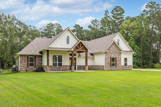 27647 N Salado Ct, Splendora, TX 77372 - view of front of home with stone siding, a front yard, and board and batten siding