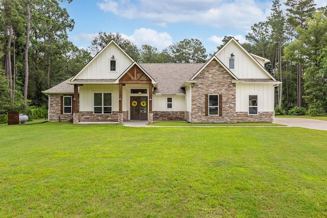 27647 N Salado Ct, Splendora, TX 77372 - view of front of home featuring stone siding, a front lawn, board and batten siding, and french doors