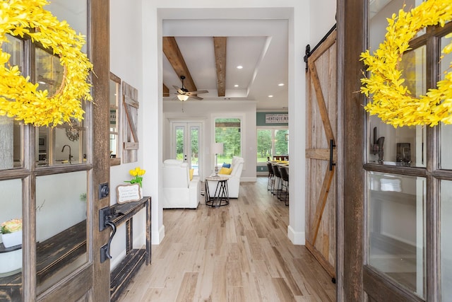 27647 N Salado Ct, Splendora, TX 77372 - entryway featuring light wood-type flooring, recessed lighting, beamed ceiling, a barn door, and ceiling fan