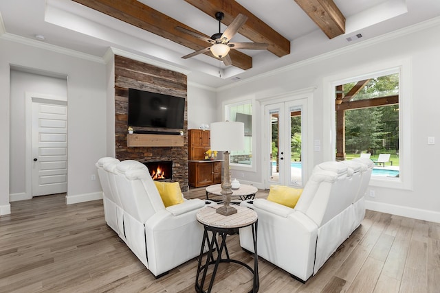 27647 N Salado Ct, Splendora, TX 77372 - living room with light wood-style flooring, a stone fireplace, a ceiling fan, beamed ceiling, and crown molding