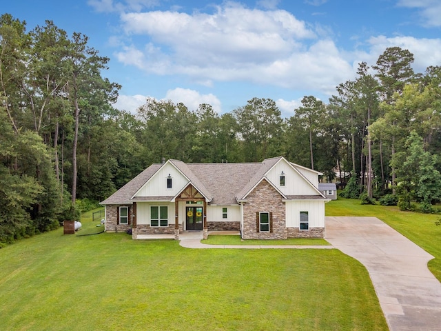 27647 N Salado Ct, Splendora, TX 77372 - modern farmhouse featuring stone siding, driveway, a front lawn, board and batten siding, and french doors