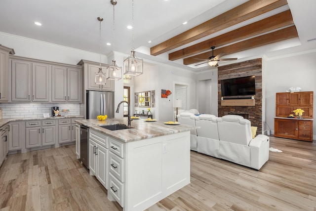27647 N Salado Ct, Splendora, TX 77372 - kitchen with appliances with stainless steel finishes, ceiling fan, decorative backsplash, a kitchen island with sink, and open floor plan