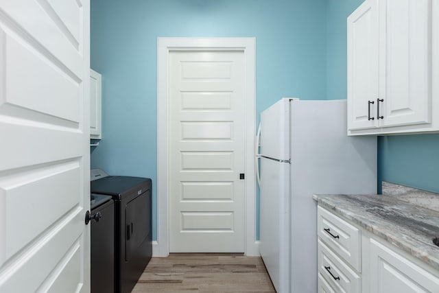 27647 N Salado Ct, Splendora, TX 77372 - kitchen featuring freestanding refrigerator, light wood-type flooring, white cabinetry, washer and clothes dryer, and light stone counters