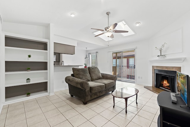 2120 El Paseo St Unit 2206, Houston, TX 77054 - living room featuring light tile patterned flooring, lofted ceiling, a tile fireplace, a ceiling fan, and built in shelves