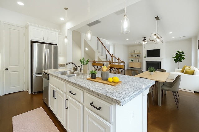 938 W 24th St, Houston, TX 77008 - kitchen with ceiling fan, stainless steel appliances, a fireplace, open floor plan, and an island with sink