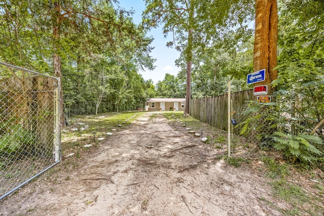 125 James Blvd, Livingston, TX 77351 - view of dirt / gravel driveway featuring a gated entry