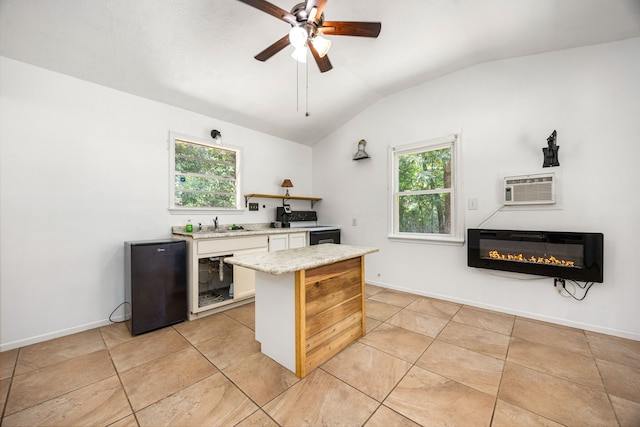 125 James Blvd, Livingston, TX 77351 - kitchen featuring heating unit, refrigerator, lofted ceiling, a glass covered fireplace, and range with electric cooktop